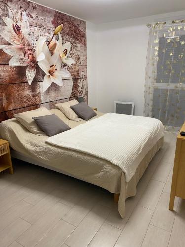 une chambre avec un grand lit avec des fleurs sur le mur dans l'établissement BLEU AZUR, à Fréjus