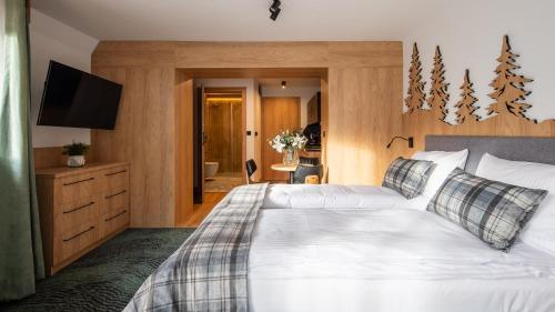 a bedroom with a white bed and a television at Aparthotel Delta Prime in Zakopane
