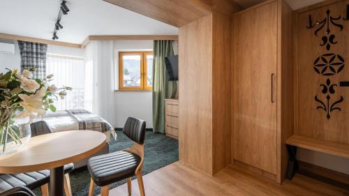 a room with a table and a bed and a bedroom at Aparthotel Delta Prime in Zakopane