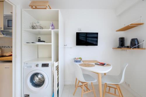 une petite cuisine avec un lave-linge et une table dans l'établissement Studio Ensoleillé - Marina Baie, à Villeneuve-Loubet