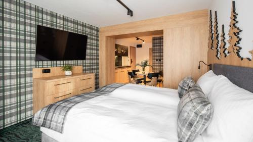 a bedroom with a bed and a flat screen tv at Aparthotel Delta Prime in Zakopane