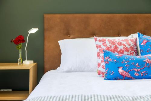 a bed with blue and red pillows at Stylish & Private near the Lake in Lake Hawea