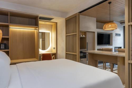 a hotel room with a white bed and a kitchen at Radisson Blu Hotel, Kas in Kas