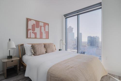 Un dormitorio con una cama blanca y una ventana grande. en Blueground Downtown pool AC nr Capitol ATX-292, en Austin