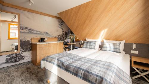 a bedroom with a large bed with a wooden headboard at Aparthotel Delta Prime in Zakopane