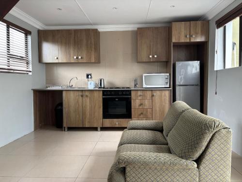 a kitchen with wooden cabinets and a couch in it at Aspire on Meier in East London