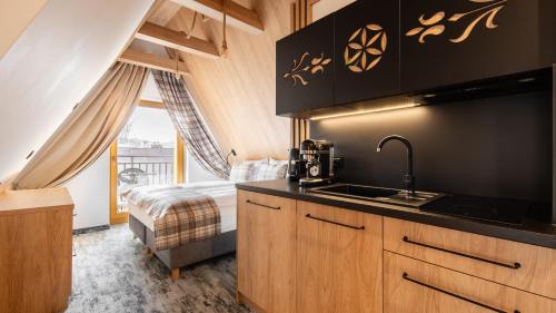 a kitchen with a sink and a bed in a room at Aparthotel Delta Prime in Zakopane