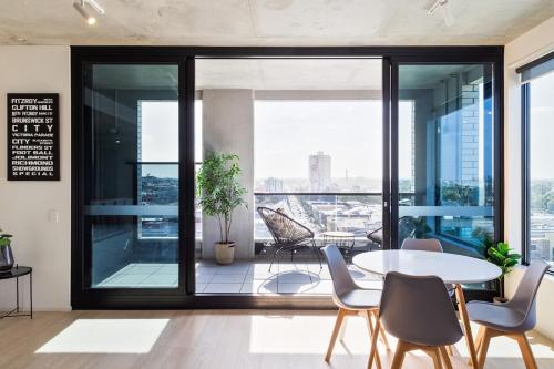 a room with a table and chairs and a large window at Penthouse Apartment Collingwood in Melbourne