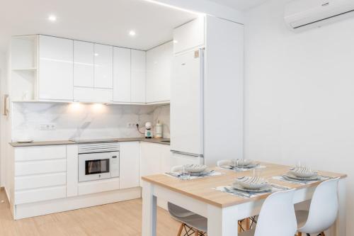 a kitchen with a wooden table and white cabinets at Vistamar in Moraira