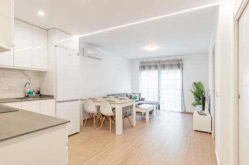 a kitchen and dining room with white cabinets and a table at Vistamar in Moraira