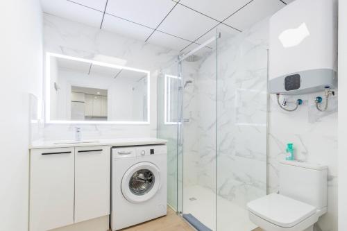 a white bathroom with a washing machine and a shower at Vistamar in Moraira