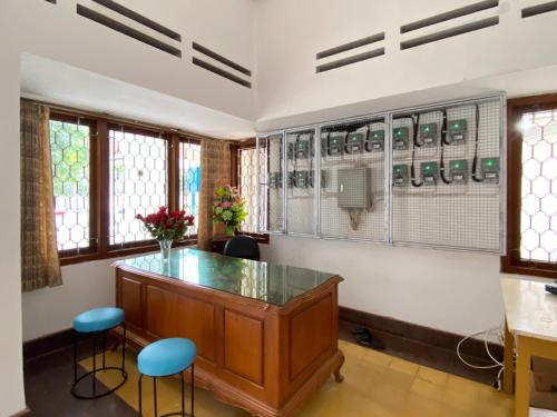 a room with a desk and two chairs and windows at RedDoorz near RSUD Tidar Magelang in Magelang