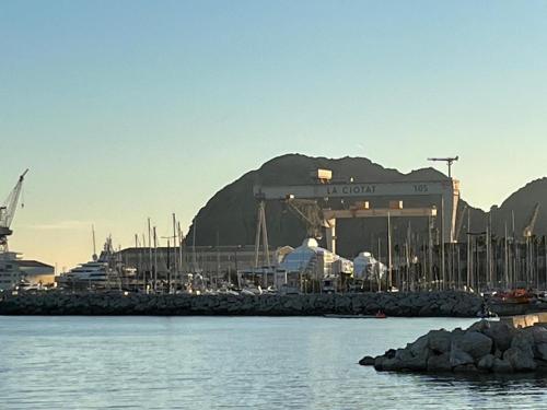un port de plaisance avec un bâtiment et des montagnes en arrière-plan dans l'établissement Villa sécurisée pres des lecques, à Saint-Cyr-sur-Mer