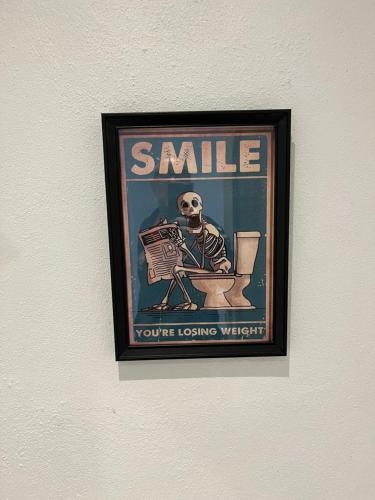 a framed picture of a skeleton sitting in the toilet at Billund Mini Hostel room 15 in Billund