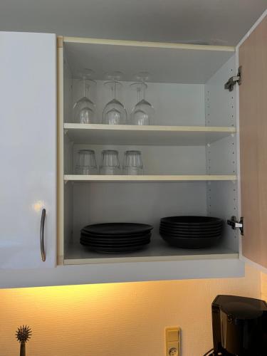 a cupboard with plates and dishes in it at Billund Mini Hostel room 15 in Billund