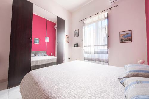 a bedroom with a white bed and a mirror at Casa Via Medici in Milazzo