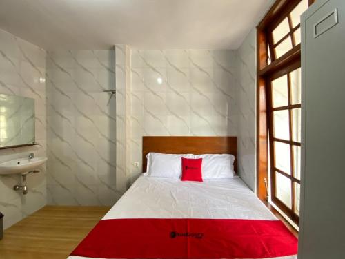 a bedroom with a bed with a red pillow at RedDoorz near RSUD Tidar Magelang in Magelang