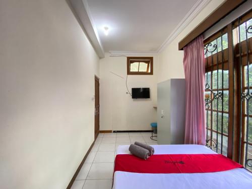 a bedroom with a bed and a large window at RedDoorz near RSUD Tidar Magelang in Magelang