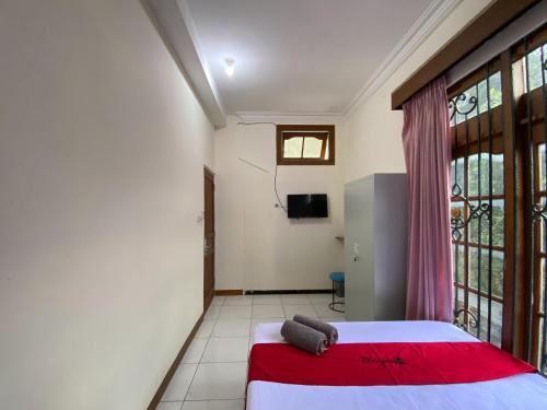 a bedroom with a bed and a large window at RedDoorz near RSUD Tidar Magelang in Magelang