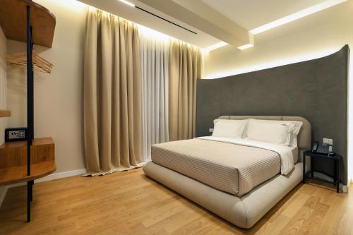 a bedroom with a white bed and a large window at Beratinus1 in Berat