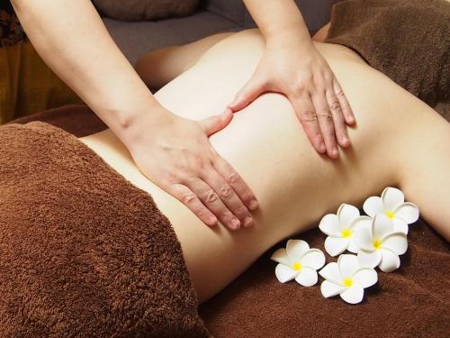 a woman getting a massage with white flowers at -SPA RESORT- Nagoya Kasadera Hotel in Nagoya