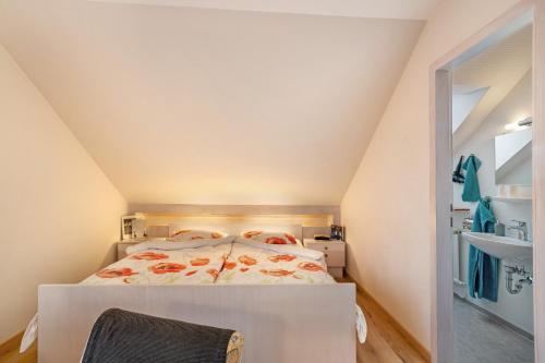 a small attic bedroom with a bed and a bathroom at Haus Bührer in Freiamt