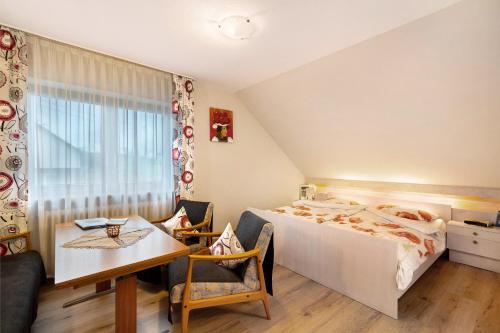 a bedroom with a bed and a desk and a table at Haus Bührer in Freiamt