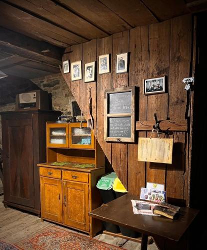 a kitchen with a wooden wall with pictures on it at Zum oidn Schmie Haus in Pemfling