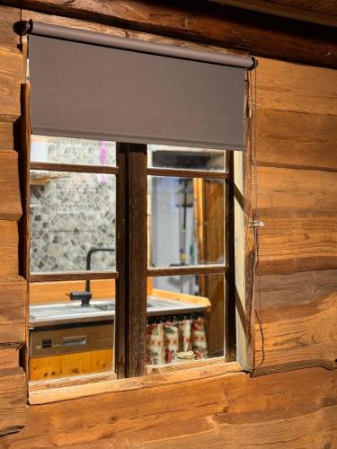 a window in a wooden house with a blind at Zum oidn Schmie Haus in Pemfling