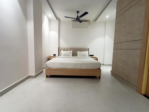 a bedroom with a bed and a ceiling fan at Hotel Global inn -1 KM From Railway Station - Lift Food And Free Parking in Lucknow