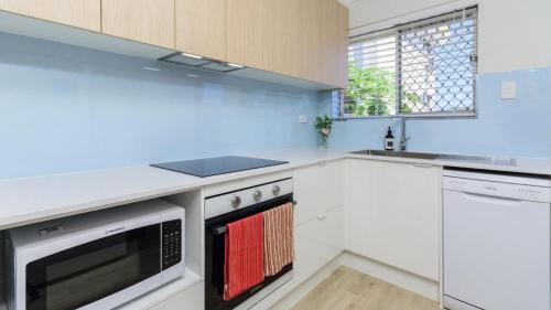 a kitchen with white appliances and a window at 'deja Blue' in Bongaree