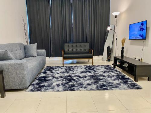 a living room with a couch and a chair at Tulis Thooleep Homestay in Chemor