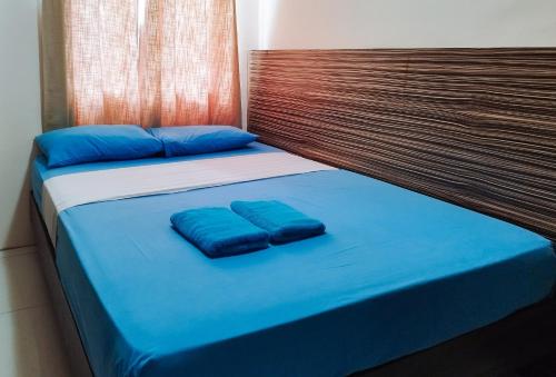 a bed with two blue pillows on top of it at RedDoorz at Sir G Hotel D'Mall Boracay in Boracay