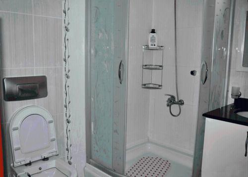 a bathroom with a shower with a toilet and a sink at Ezgi Apart in Karaoz