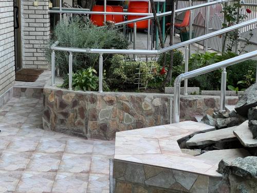 a patio with a stone bench and some plants at Slobo Velickovic in Prokuplje