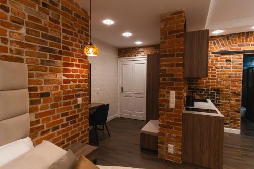 a living room with a brick wall and a kitchen at Apartamenty Piernikowe in Toruń