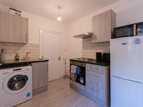 a kitchen with a refrigerator and a washing machine at Studio flat in Heart of Southend - Pass the Keys in Southend-on-Sea