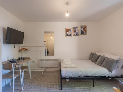a bedroom with a bed and a desk and a television at Studio flat in Heart of Southend - Pass the Keys in Southend-on-Sea
