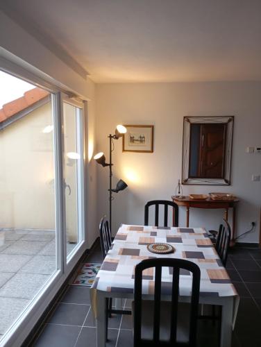 una sala da pranzo con tavolo, sedie e una finestra di La bonne adresse a Woippy