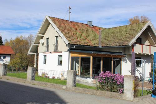 a white house with flowers in front of it at Ferienwohnung Jolie in Sankt Oswald