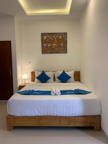 a bedroom with a large bed with blue pillows at The Carik Bisma Ubud in Ubud