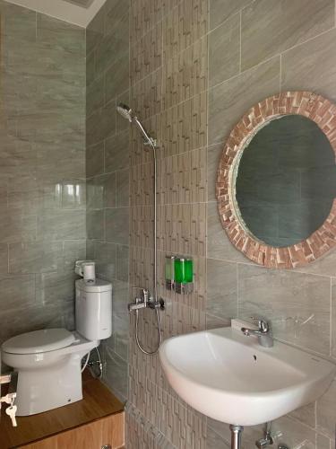 a bathroom with a sink and a toilet and a mirror at The Carik Bisma Ubud in Ubud