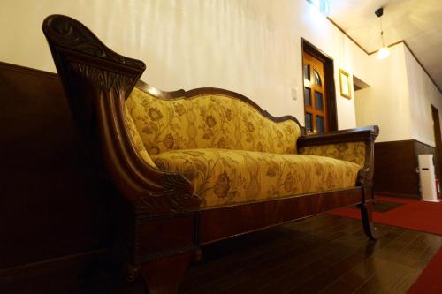 a fancy couch in a room with a staircase at ゲストハウス桜月荘 in Kagoshima