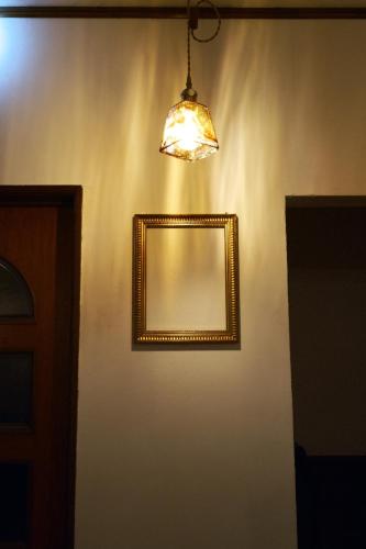 a mirror on a wall with a light and a lamp at ゲストハウス桜月荘 in Kagoshima