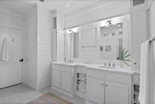 a white bathroom with two sinks and a mirror at Southern Charm in Santa Rosa Beach