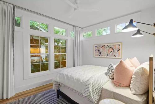 a white bedroom with a bed and windows at Southern Charm in Santa Rosa Beach