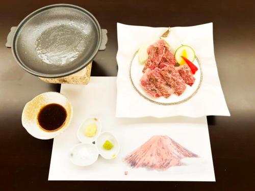 a table with a plate of food and a cup of coffee at Shuzenji Onsen Hotel Takitei in Izu