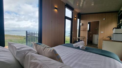 a bedroom with a bed with a view of the ocean at Aorangi Peak Cabins 6 by Tiny Away in Rotorua