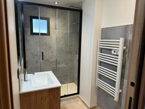 une salle de bain avec un lavabo et une douche dans l'établissement Odalys Chalet L'Arpette Lodge, à La Plagne Tarentaise