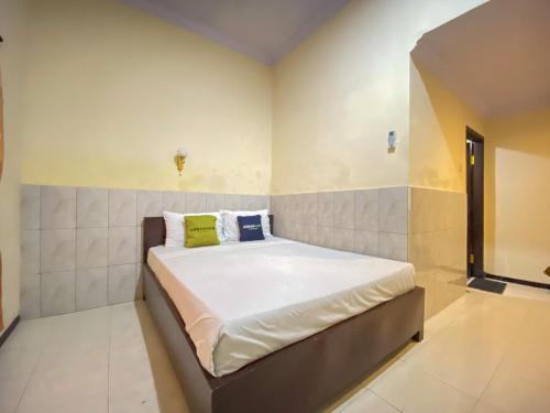 a small bedroom with a bed in it at Surya Guest House Urbanview Probolinggo in Kanigaran